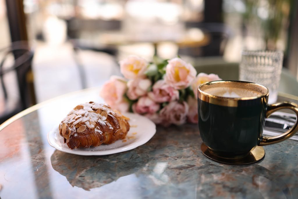 A coffee cup and pastry on a table