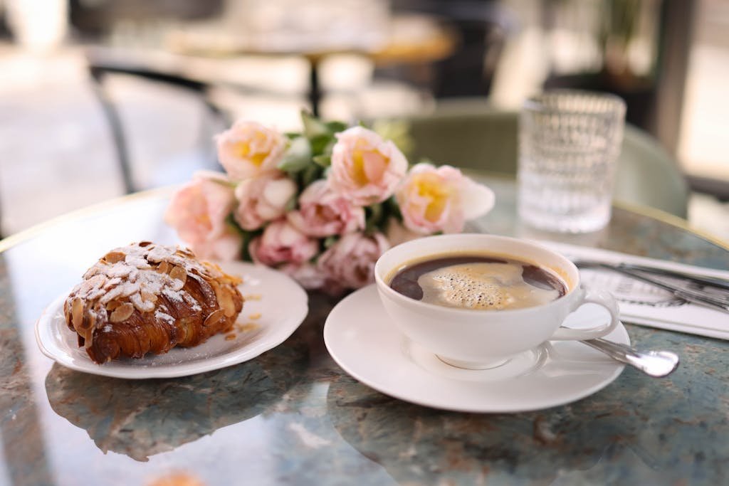 A cup of coffee and a pastry on a table