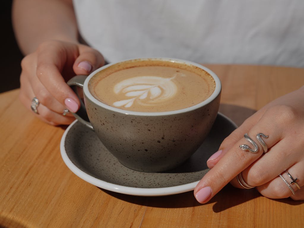 A woman's hand holding a cup of coffee