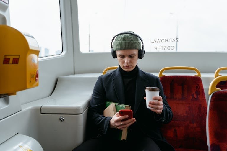 Person Holding Cup and Mobile Phone